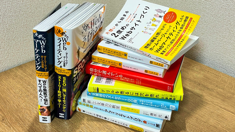 段ボールから引っ張り出した複数の書籍。山積みになっている写真。